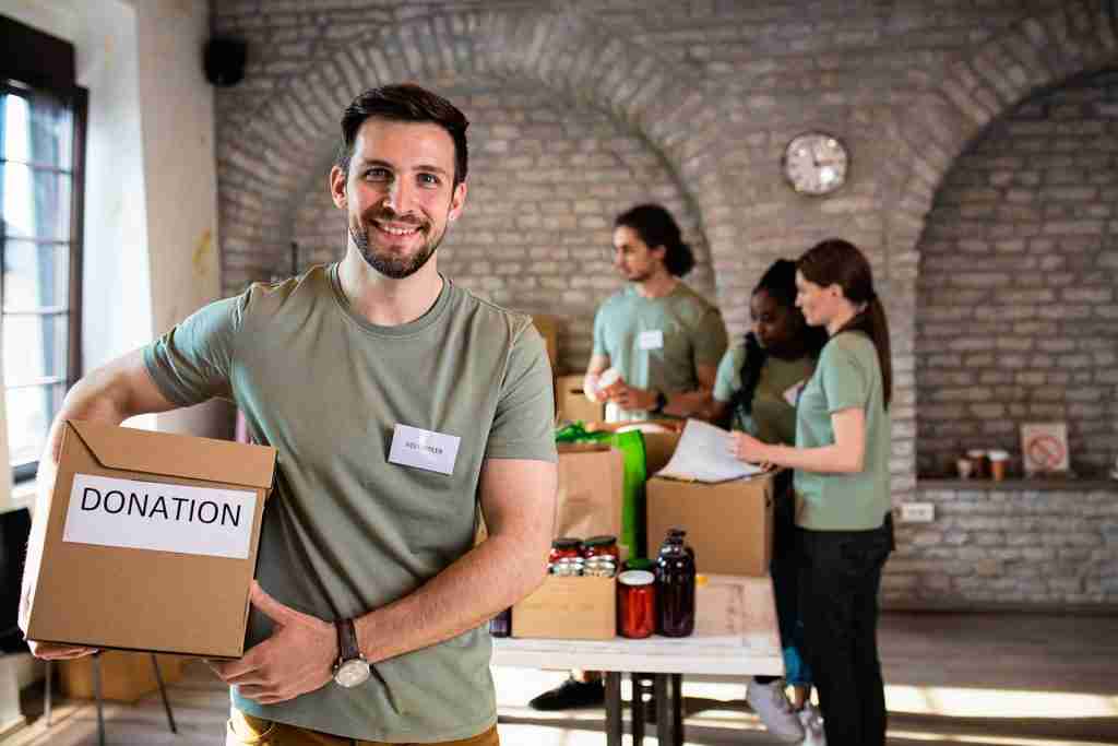 portrait-of-male-volunteer-holding-a-box-with-dona-2023-11-27-05-29-43-utc